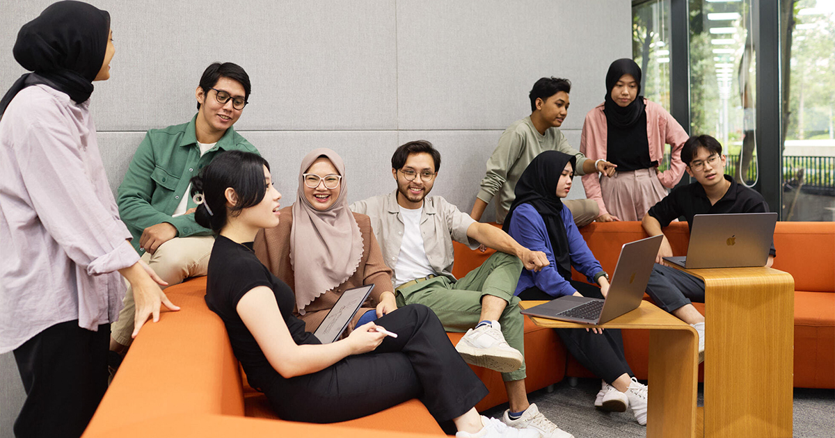 オレンジ色のソファのあるラウンジエリアで共同作業を行うデベロッパたち