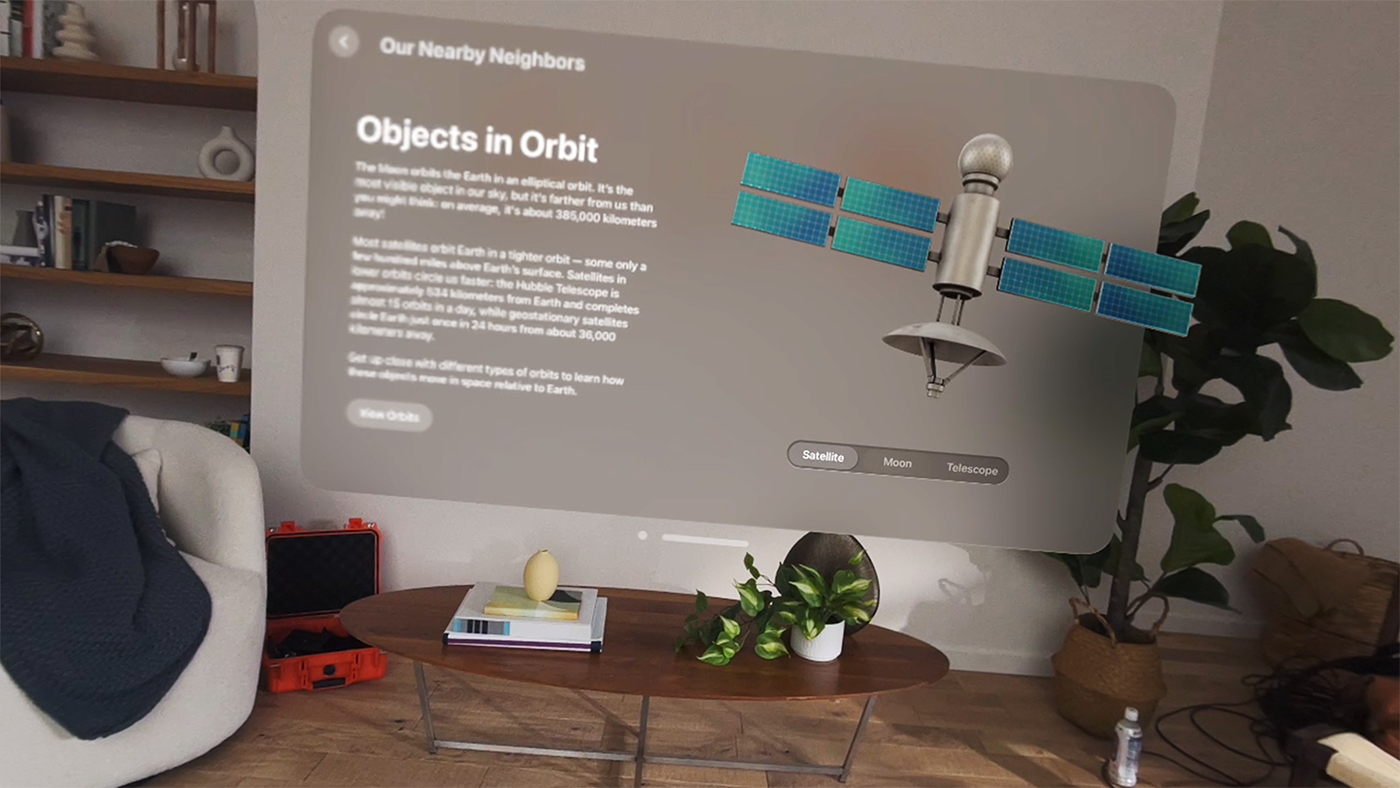 A screenshot of the Hello World app on Apple Vision Pro that illustrates things to avoid when creating screenshots. The app appears in a living room, but the window is tilted and askew, the image is partially, blurry, and the background is cluttered with cords, a water bottle, and other objects.